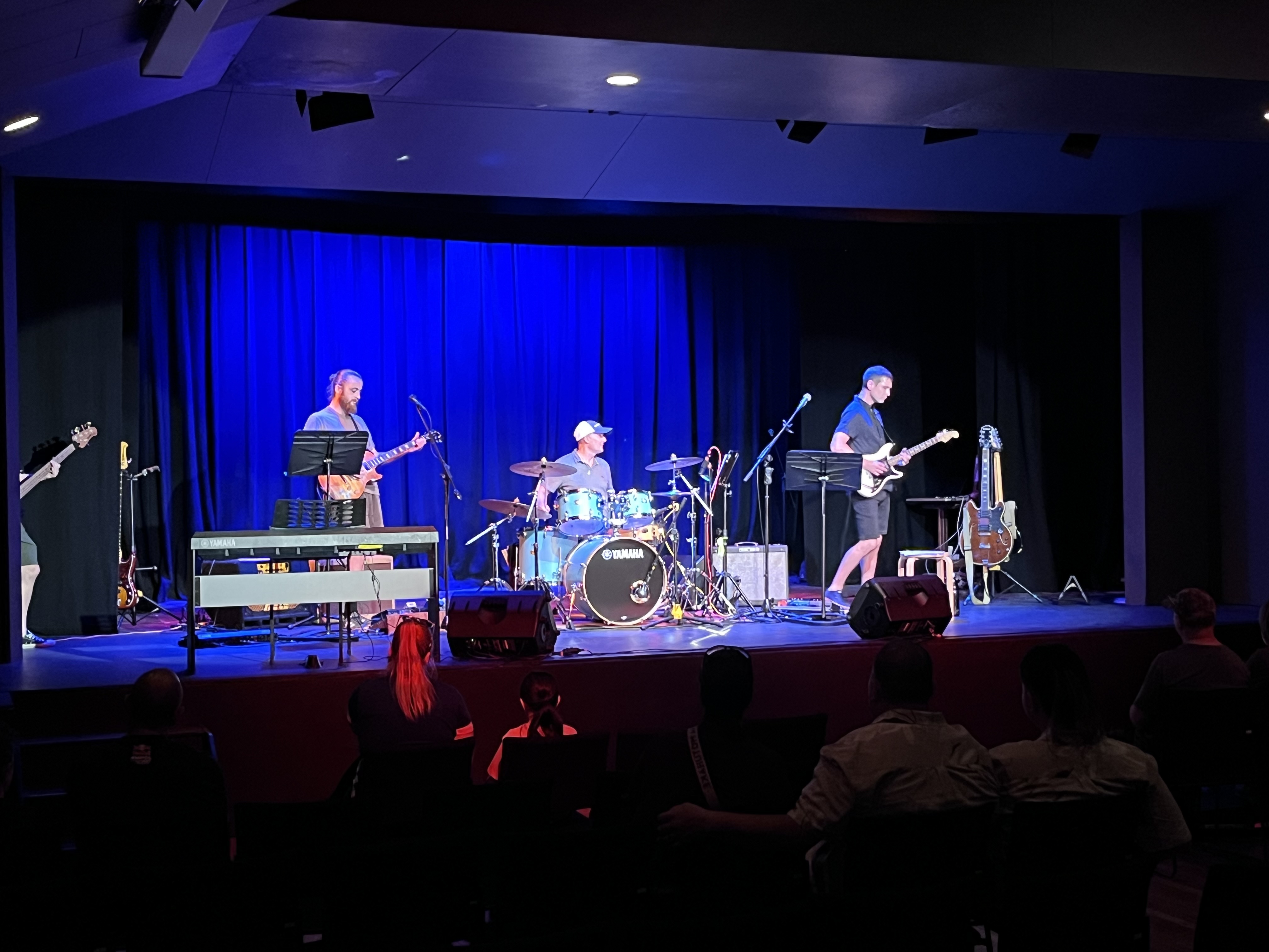 Students performing as a band to a seated audience