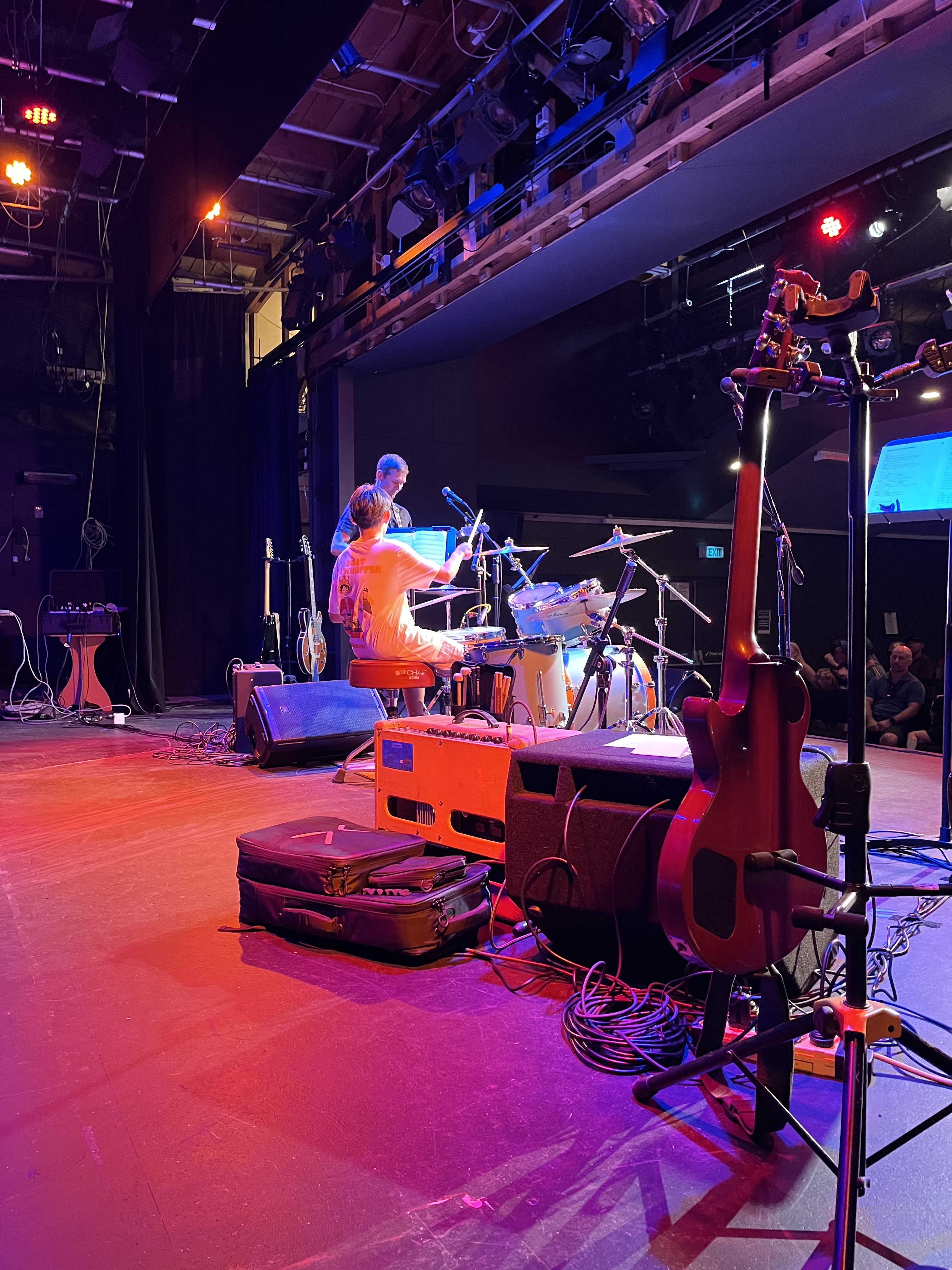 A student drummer performing under stage lights