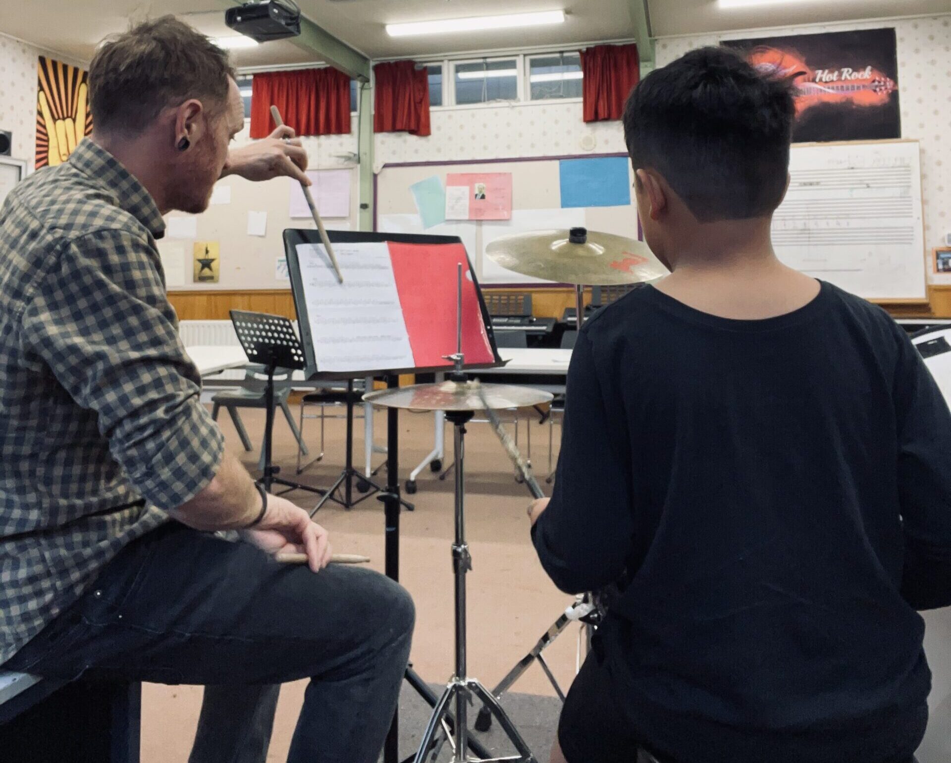 A tutor talking a student through a drum chart mid-lesson